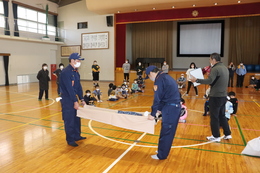 消防団が見本で作り方を教えています(ホームページ委員会撮影) 消防団が見本で作り方を教えています