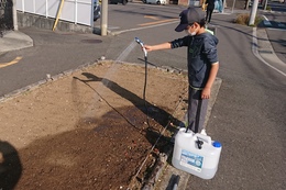 植え終わって軽く水やりしています(衛生組合協議会撮影) 植え終わって軽く水やりしています