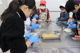 丸めたあんこをご飯で包んでいます(ホームページ委員会撮影) 丸めたあんこをご飯で包んでいます
