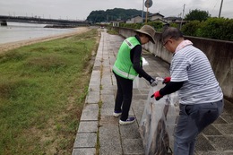 漂着ごみを片付ける環境衛生組合長さん(環境衛生組合協議会撮影) 漂着ごみを片付ける環境衛生組合長さん