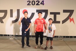 ラムネ早飲みで勝利し金メダルをかけてもらった参加者です(ホームページ委員会撮影) ラムネ早飲みで勝利し金メダルをかけてもらった参加者です