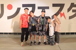 ラムネ早飲みで勝利し金メダルをかけてもらった参加者です(ホームページ委員会撮影) ラムネ早飲みで勝利し金メダルをかけてもらった参加者です