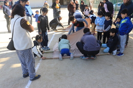 竹竿と毛布で担架をつくり(ホームページ委員会撮影) 竹竿と毛布で担架をつくり